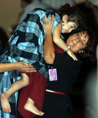 
A young passenger is carried by an unidentified person after the jetliner she was a passenger on slid off the runway and crashed Tuesday at the Toronto airport. 
 (Associated Press photos / The Spokesman-Review)