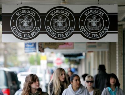 Signs for the original Starbucks coffeehouse store hang in the Pike Place Market in Seattle. (FileAssociated Press / The Spokesman-Review)