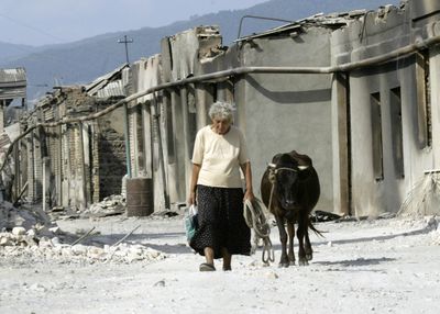 A woman leads her cow along a ruined street in Tskhinvali, the regional capital of Georgia’s breakaway province of South Ossetia, Friday.  (Associated Press / The Spokesman-Review)