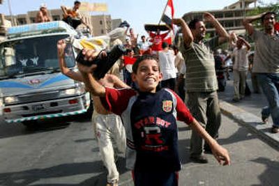 
An Iraqi boy waves a toy pistol in central Baghdad on Wednesday after the country's national soccer team  advanced to the Asian Cup finals. Two subsequent car bombings killed at least 50 celebrants. Associated Press
 (Associated Press / The Spokesman-Review)