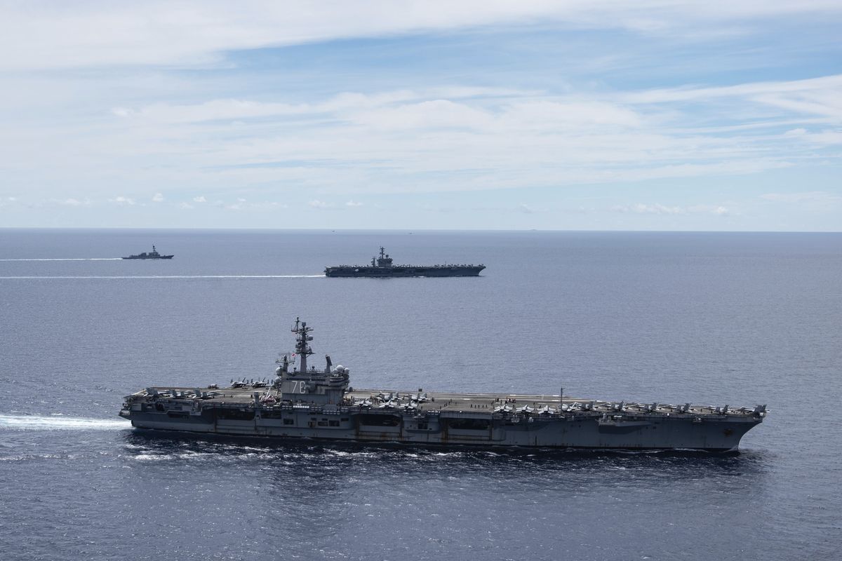 In this photo provided by U.S. Navy, the USS Ronald Reagan (CVN 76, front) and USS Nimitz (CVN 68, rear) Carrier Strike Groups sail together in formation, in the South China Sea, Monday, July 6, 2020. China on Monday, July 6, accused the U.S. of flexing its military muscles in the South China Sea by conducting joint exercises with two U.S. aircraft carrier groups in the strategic waterway. (Petty Officer 3rd Class Jason Tarleton)
