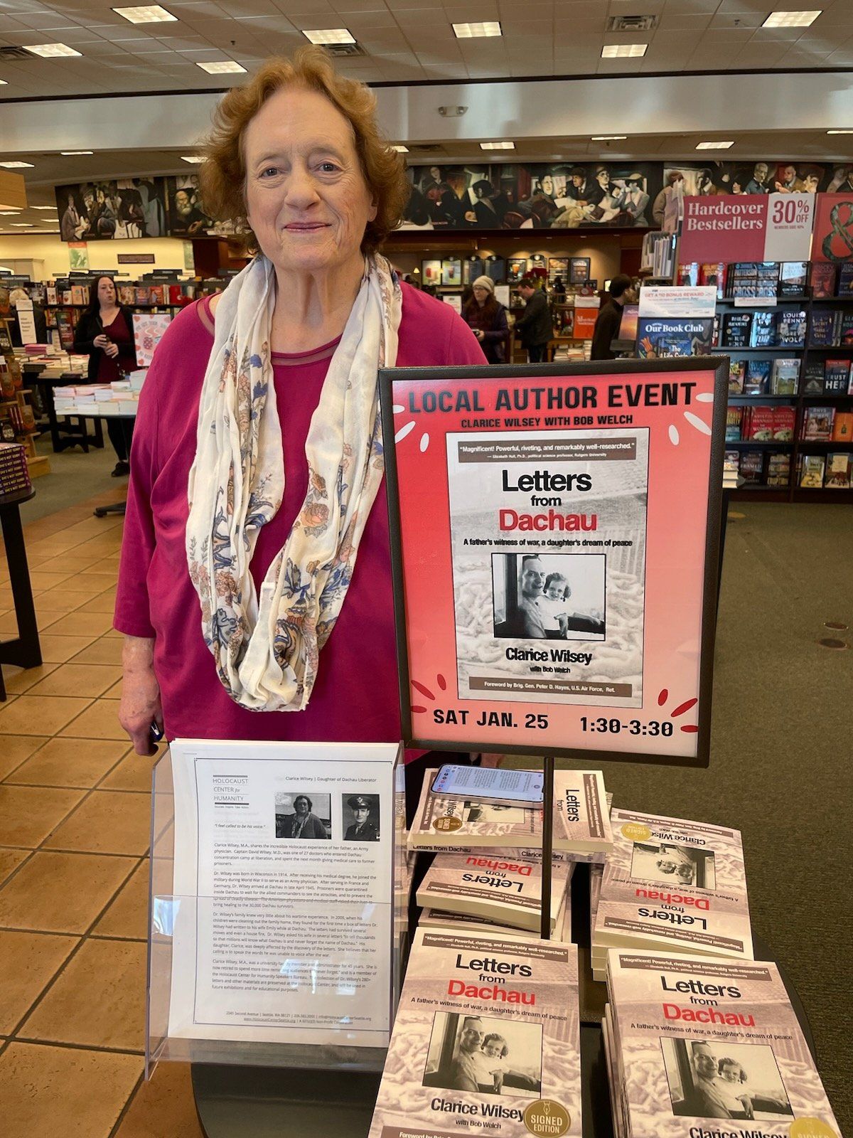 Clarice Wilsey poses among stacks of her book, “Letters from Dachau: A father’s witness of war, a daughter’s dream of peace” at a Barnes and Noble. (Courtesy of Clarice Wilsey)
