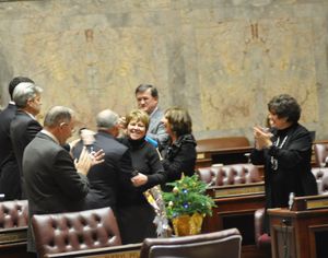 OLYMPIA -- Senate Majority Leader Lisa Brown, D-Spokane, and Minority Leader Mike Hewitt, R-Walla Walla, hug while other senators including Mike Padden, R-Spokane Valley (left) applaud as the gavel comes down to adjourn the Legislature's special session. (Jim Camden)
