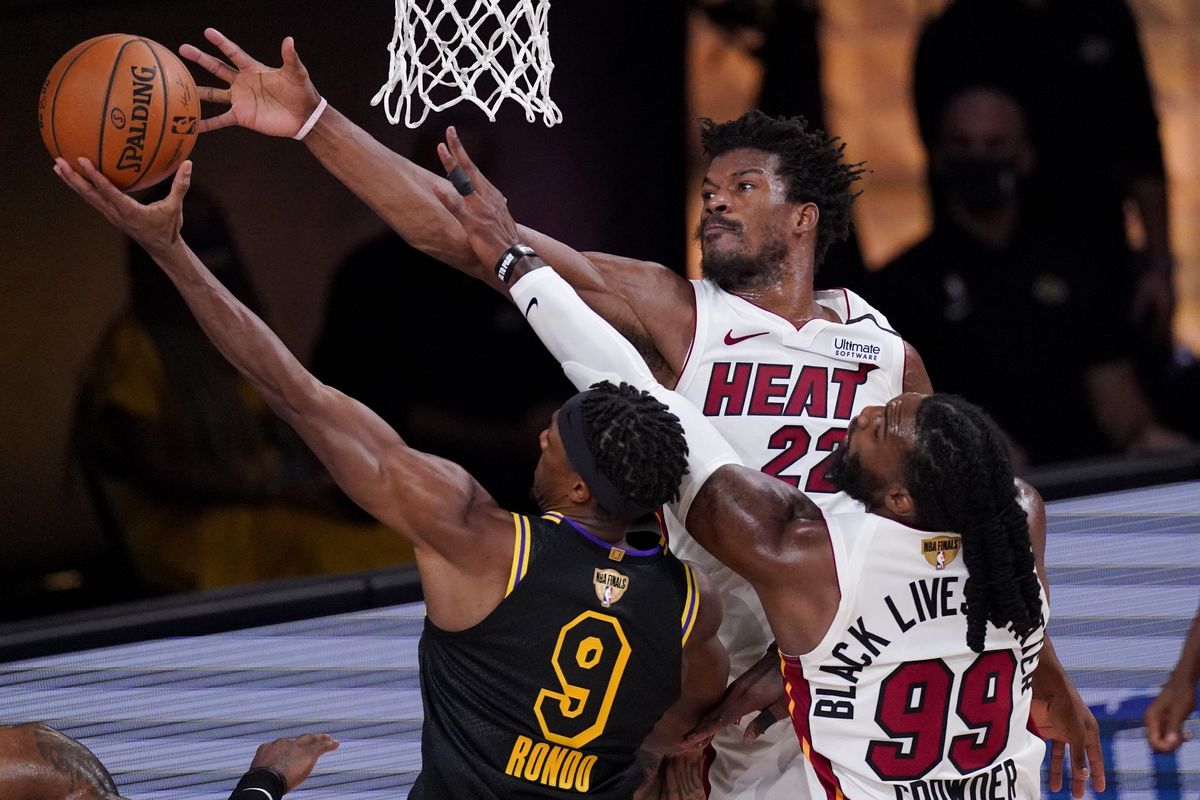 Los Angeles Lakers guard Rajon Rondo shoots over Miami Heat forward Jae Crowder, right, and forward Jimmy Butler during the first half Friday.  (Associated Press)