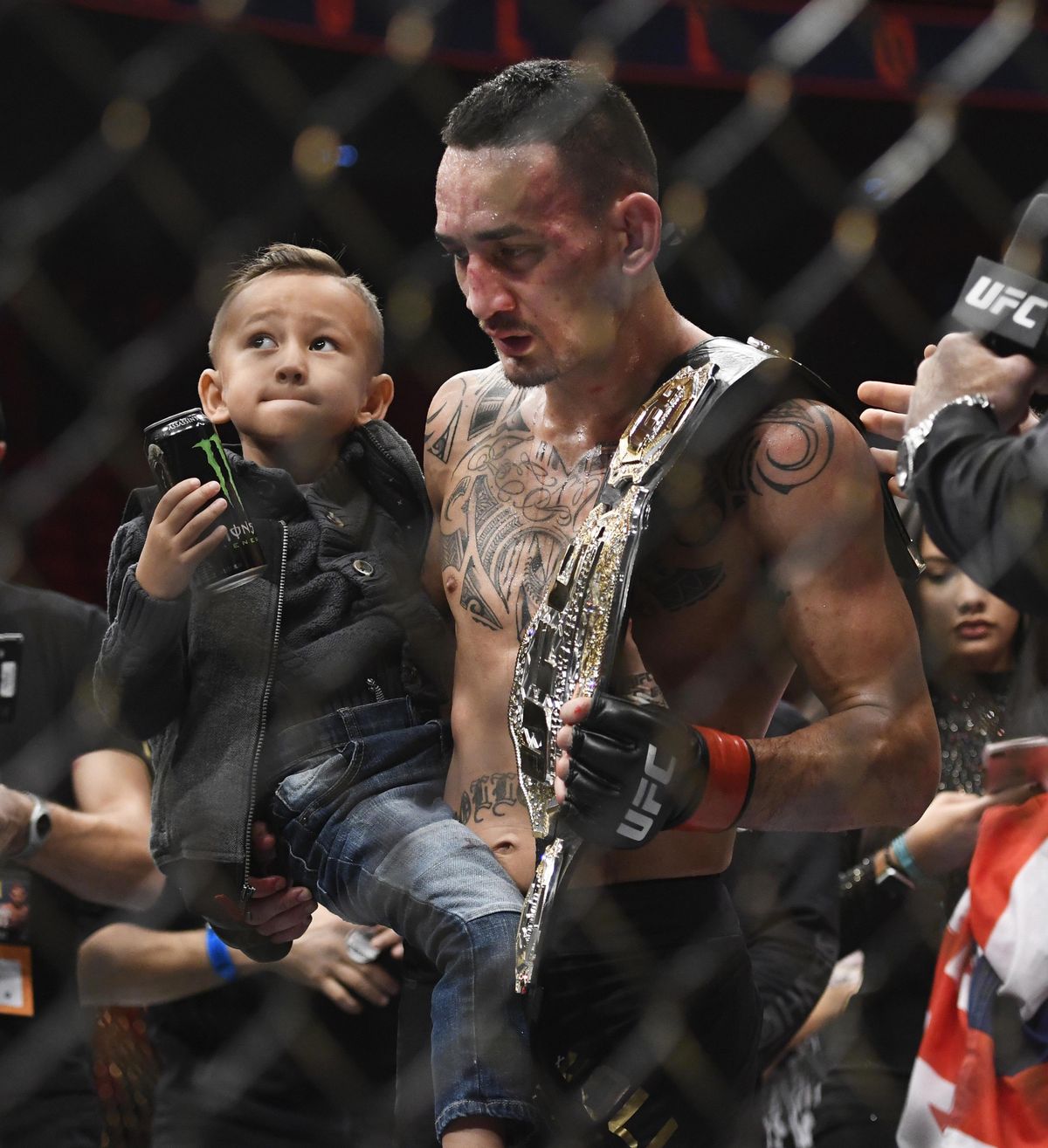 Max Holloway holds his son Rush, after Holloway defeated Jose Aldo, of Brazil, during a UFC 218 featherweight mixed martial arts bout, early Sunday, Dec. 3, 2017, in Detroit. (Jose Juarez / Associated Press)