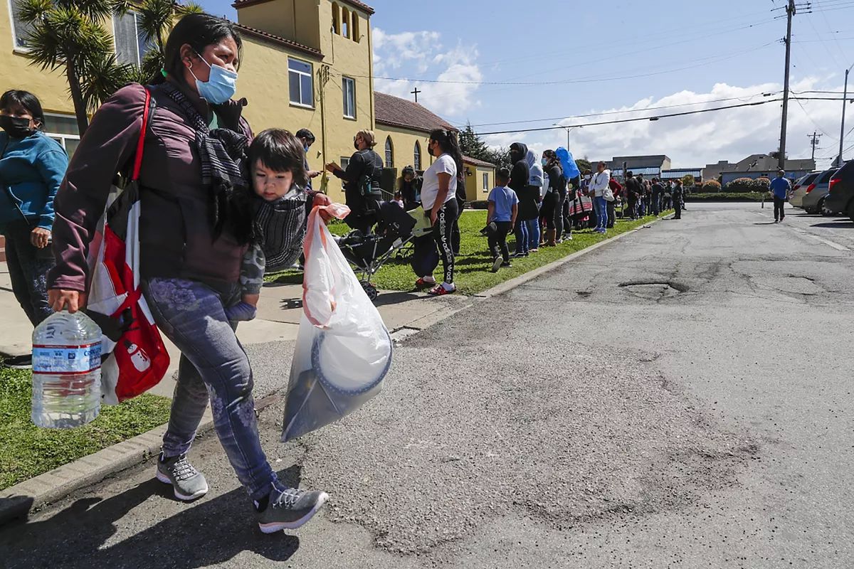 Residents of Monterey and Santa Cruz counties, many displaced by flooding in Pajaro, stand in a long line to receive supplies at a Watsonville church. (Robert Gauthier/Los Angeles Times/TNS)  (Robert Gauthier/Los Angeles Times/TNS)