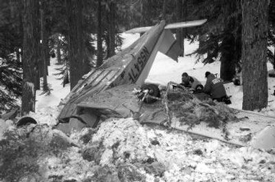 
Rescuers on Tuesday  treat  one of two men who survived a cold night after their  plane crashed in  the Cascades  near Crescent, Ore. The plane went down after developing engine trouble Monday. 
 (Associated Press / The Spokesman-Review)