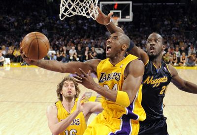 Lakers guard Kobe Bryant puts up a shot between teammate Pau Gasol, left, and Nuggets Johan Petro. Bryant scored 33 points.  (Associated Press / The Spokesman-Review)