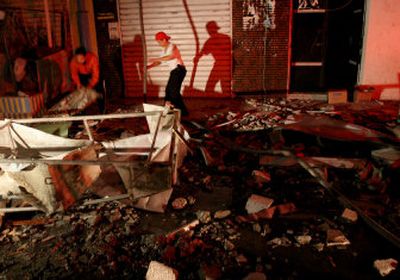 
Palestinians work outside a building hit in an Israeli airstrike early today in Gaza City; the building was allegedly used by the militant group al-Aqsa Martyrs Brigades. 
 (Associated Press / The Spokesman-Review)
