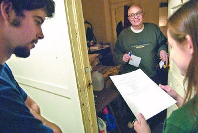
Seth, center, a resident at the Otis Hotel, smiles as Margaret Mitsuyasu, right, and Kevin Weiser play a word game Seth gave them during a recent visit. Mitsuyasu and Weiser, of Whitworth College's student-run ministry En Christo, had brought a sack lunch for Seth.
 (INGRID LINDEMANN PHOTOS / The Spokesman-Review)