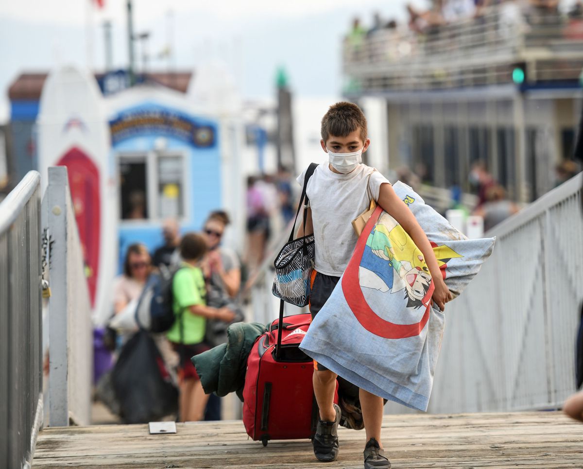 Eight-year-old Atlas Kammarcal of Spokane arrives at Independence Point in Coeur d’Alene on Tuesday, Aug. 3, 2021, after his stay at Camp Sweyolakan was cut short due to poor air quality.  (Kathy Plonka/The Spokesman-Review)