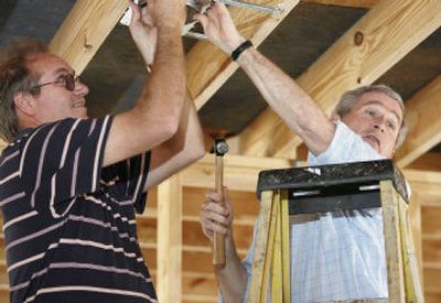 
President Bush, right, hammers a nail with James Akins Wednesday during a visit to a home destroyed by Hurricane Katrina in Gautier, Miss.,  in the Gulf Coast region.
 (Associated Press / The Spokesman-Review)