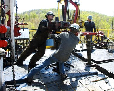 Workers move a section of natural gas well casing into place at a site near Burlington, Pa. (Associated Press)