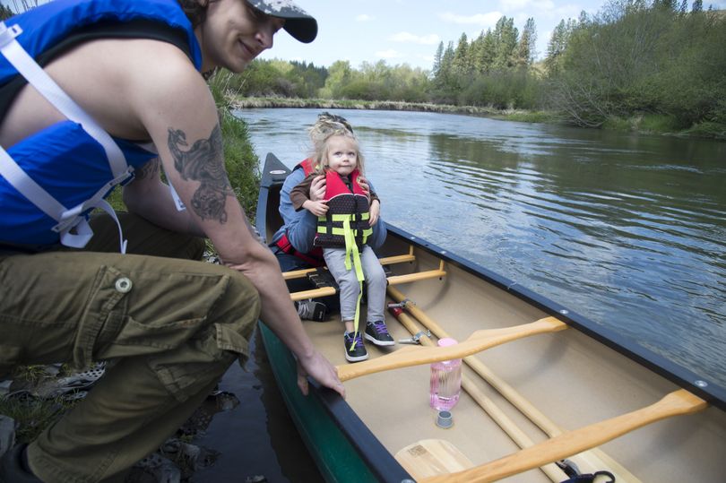Marissa Puckett, center, and her daughter, Kaelynn, 2, prepare to take a canoe ride Thursday on the Little Spokane River with Justin Enlow, left, after putting in near St. George’s School. This year’s minimal winter snowpack will affect river flows. (Jesse Tinsley)