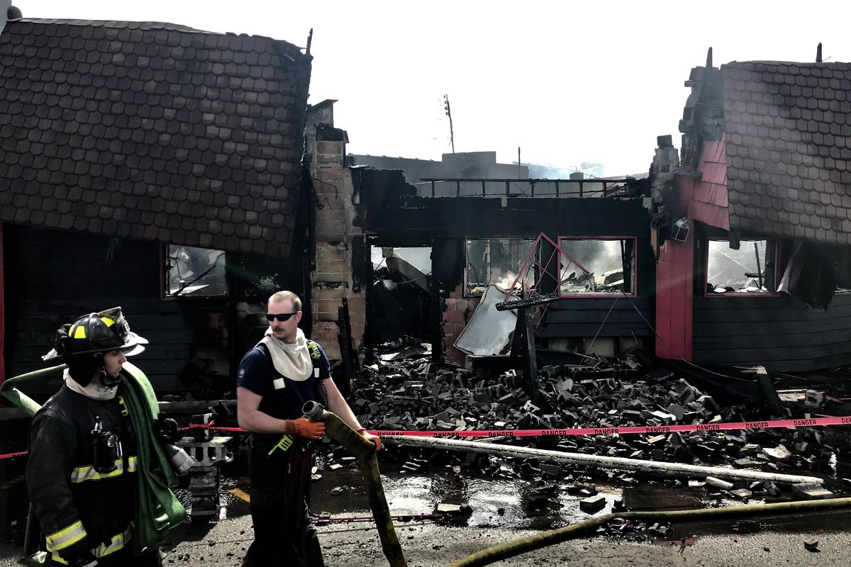 Spokane firefighters continued to pour water on Shogun Restaurant, 821 E Third Ave., multiple hours after an early-morning fire ravaged the building on Sunday, April 22, 2018. (Kathy Plonka / The Spokesman-Review)