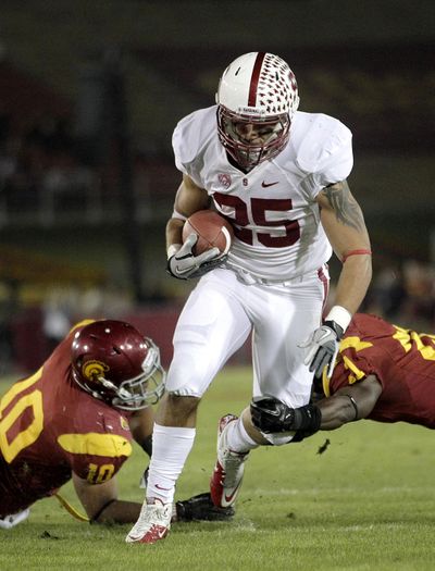 USC’s Hayes Pullard, left, and Nickell Robey try to stop Stanford’s Tyler Gaffney during the Cardinal’s win Saturday. (Associated Press)