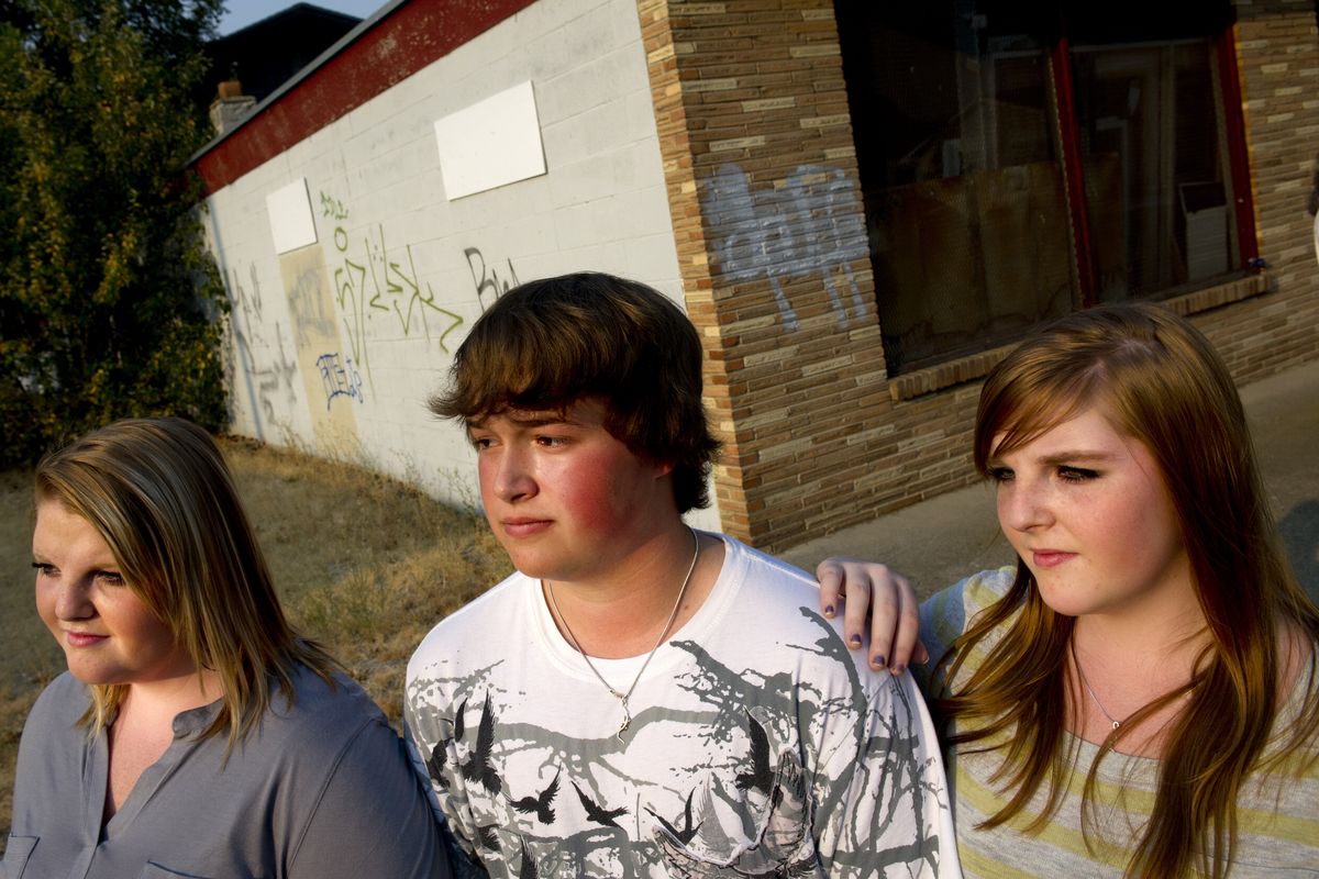 Twin sisters Elizabeth Wallace, left, and Megan Wallace pose for a photo with Dustin Schaefer on Wednesday in Spokane. The trio completed a PhotoVoice project about the types of alcohol advertising in Spokane neighborhoods. (Tyler Tjomsland)