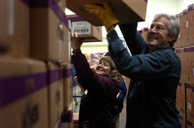
Robert Piston and Marsha Hitchcock  laugh as they stack toy boxes for the Christmas Bureau on Tuesday at the Spokane County Fair & Expo Center. 
 (Jed Conklin / The Spokesman-Review)
