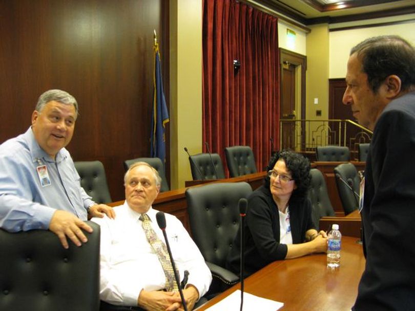 Idaho redistricting commissioners, from left, Evan Frasure, Allen Andersen, Julie Kane and George Moses talk after the finish of their business meeting on Thursday, at which they unanimously agreed on a public hearing schedule - after deadlocking over that issue a day earlier. (Betsy Russell)