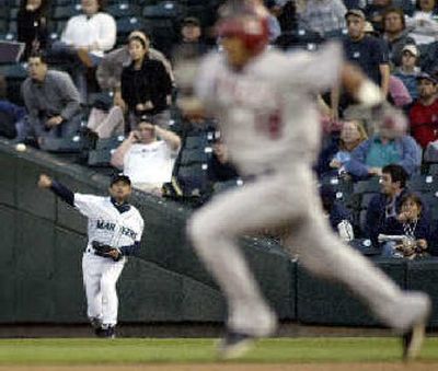 
Seattle's Ichiro Suzuki tries to throw out Orlando Cabrera. 
 (Associated Press / The Spokesman-Review)