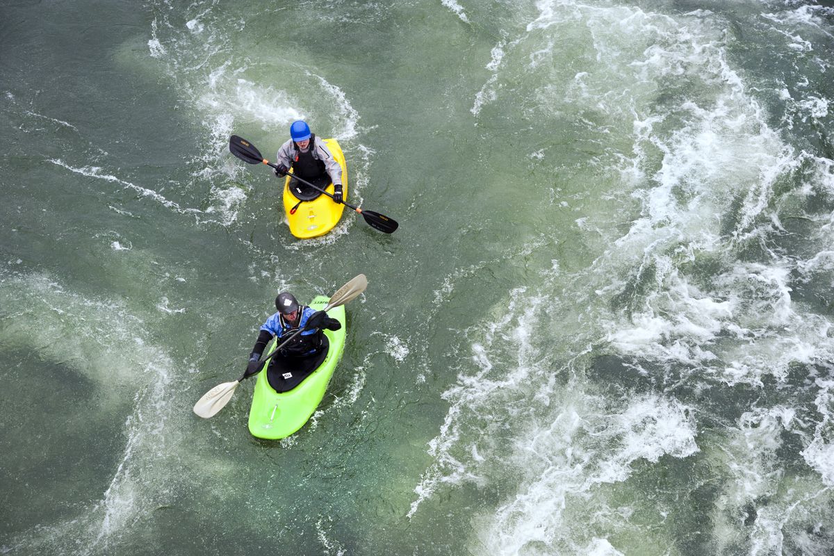 Jon Wilmot, bottom, and his son Kai play in the currents of the Spokane River under the Sadifur Bridge on March 27 in Spokane, a month ahead of schedule. (Dan Pelle)