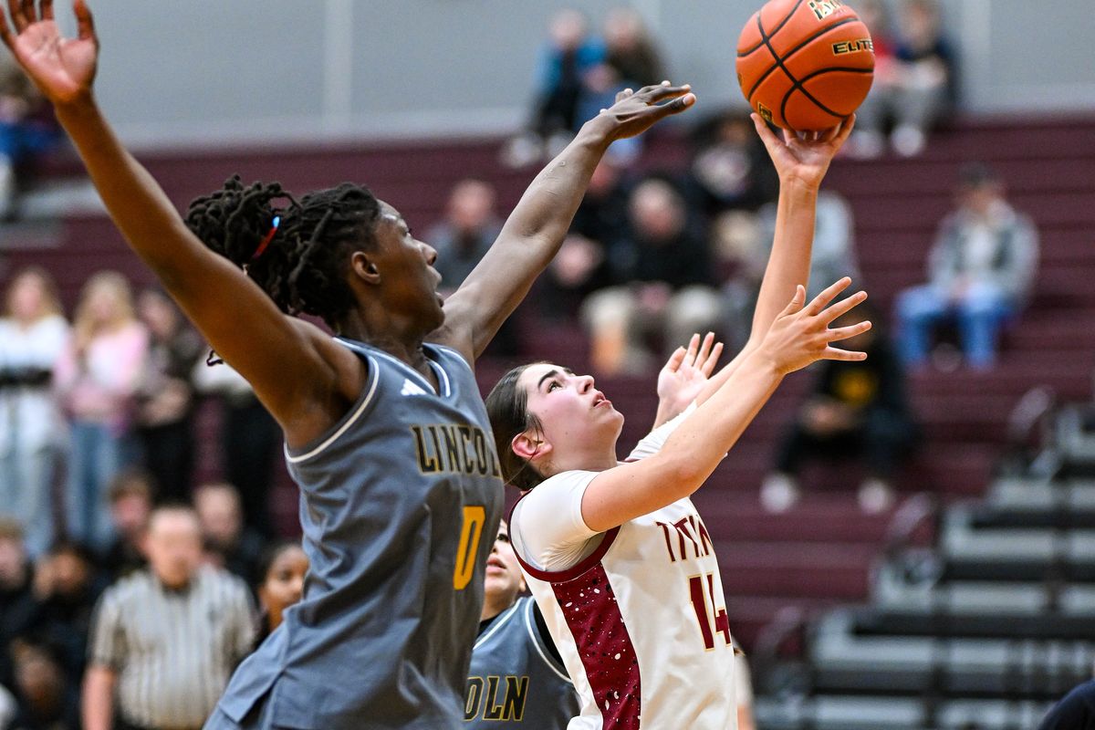 University center Kenna Ashton (14) shoots the ball as Lincoln forward Oliviyah Edward (0) defends during the first half of a high school basketball State 3A play-in game, Tuesday, Feb. 24, 2026, at University High School.  (Colin Mulvany/The Spokesman-Review)
