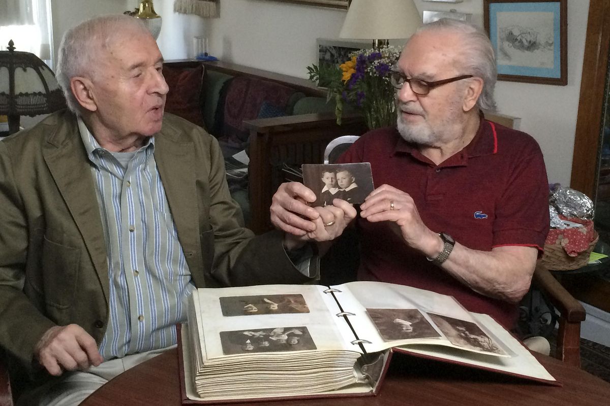 Brothers Alexander Feingold, left, and Joseph Feingold look at photo of themselves as boys in Joseph’s apartment in New York on June 8, 2015. Joseph Feingold died at age 97 of complications from the new coronavirus, four weeks after his brother Alexander, 95, died of pneumonia at the same New York hospital. The brothers were Polish-born Holocaust survivors who had a difficult relationship shaped by the trauma of the war and the loss of their beloved mother and younger brother in Treblinka. The pandemic that gripped New York prevented a final farewell. (Raphaela Neihausen / Associated Press)