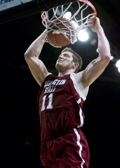 Washington State center Aron Baynes hangs from the rim after a dunk late in the second half of an NCAA college basketball game against Idaho tonight in Moscow. Washington State won 55-41. Baynes led all scorers with 18 points.  (Dean Hare / The Associated Press)