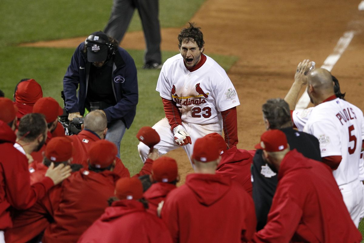 David Freese greets a mob of teammates at home plate following his home run, one of the most dramatic in World Series history. (Associated Press)
