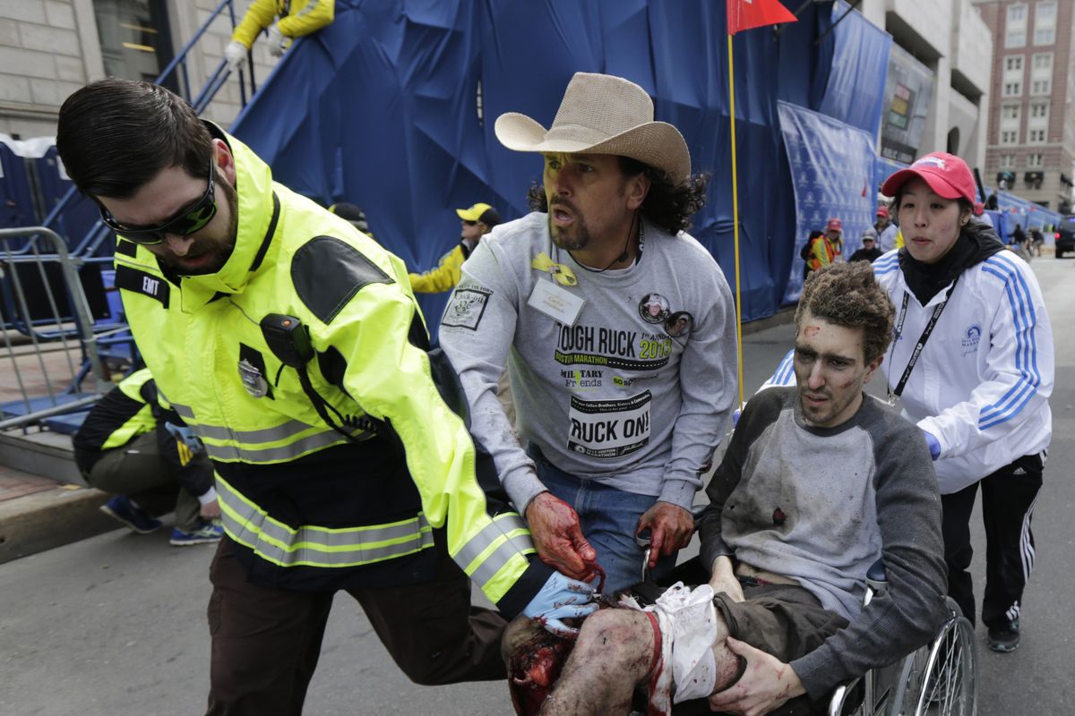 Medical responders run an injured man, later identified as 27-year-old Jeff Bauman Jr., past the finish line of the 2013 Boston Marathon following an explosion in Boston on Monday. Bauman ended up having both legs amputated due to the injuries he sustained. (Associated Press)
