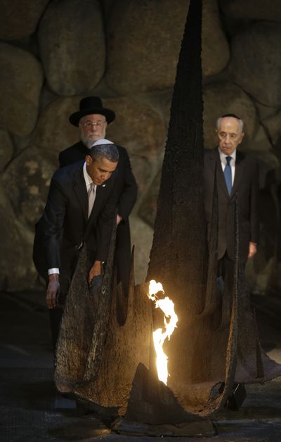 U.S. President Barack Obama, left, reignites the flame during his visit to the the Hall of Remembrance at the Vad Vashem Holocaust Memorial in Jerusalem, Israel, Friday, March 22, 2013. Standing behind Obama are Rabbi Israel Meir Lau, left, and Israeli President Shimon Peres. (Pablo Monsivais / Associated Press)