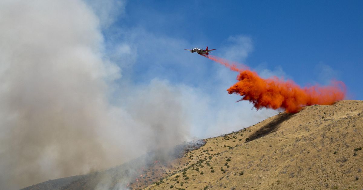 A plane drops fire retardant on a wildfire behind Lucky Peak Reservoir just off of Idaho State Highway 21 in Boise, Idaho, Tuesday, July 19, 2016. (Kyle Green / Associated Press)