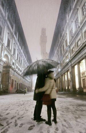 FILE-A couple kiss each other during a snowfall in Florence, Italy, late Wednesday, Dec. 28, 2005. (Lorenzo Galassi / Associated Press)