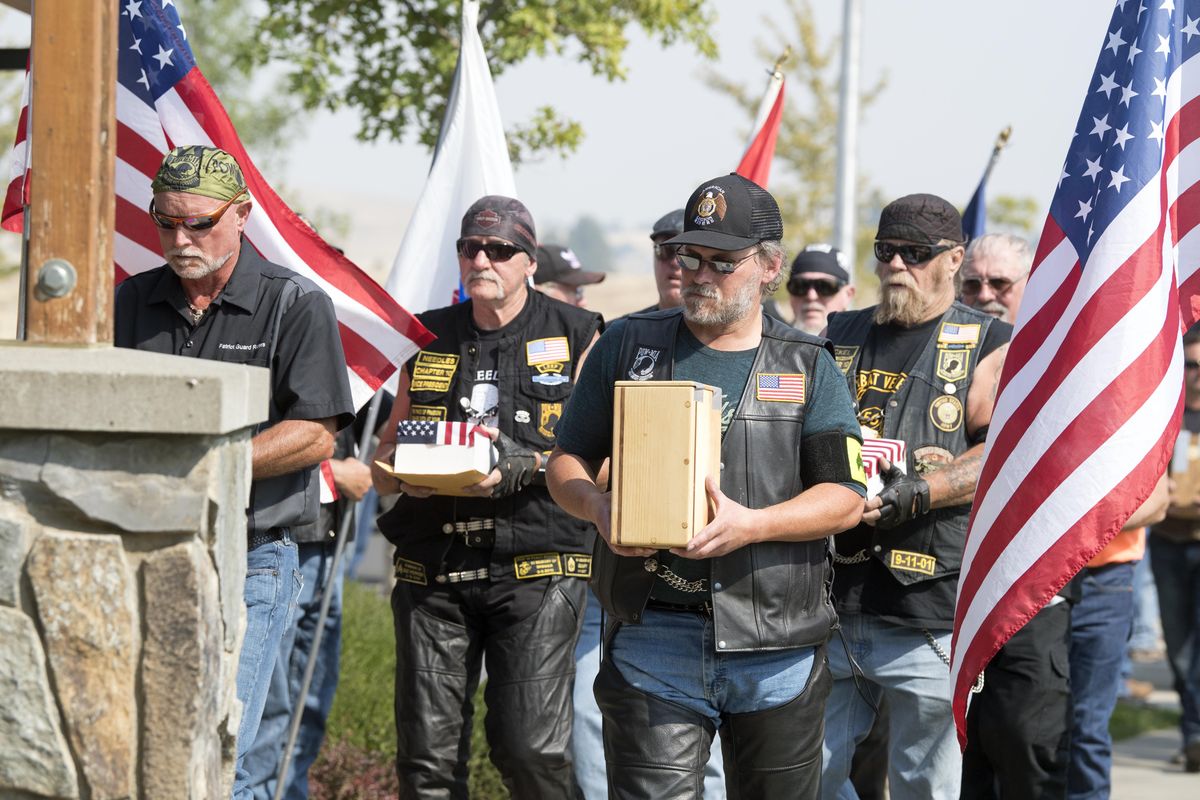 Veterans walk in procession to deliver the ashes of more than 20 deceased veterans from the west side of Washington state after delivering them by motorcycle, Wednesday, Aug. 30, 2017, at the Washington State Veterans Cemetery in Medical Lake, Wash. With the establishment of the Medical Lake cemetery, funeral homes and veteran volunteers seek out the unclaimed ashes of deceased veterans and, after research to establish their service, bring the ashes to Medical Lake for eventual interment. (Jesse Tinsley / The Spokesman-Review)