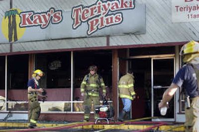 
Firefighters mop up after a fire damaged Kay's Teriyaki Plus on Wednesday. 
 (Christopher Anderson / The Spokesman-Review)
