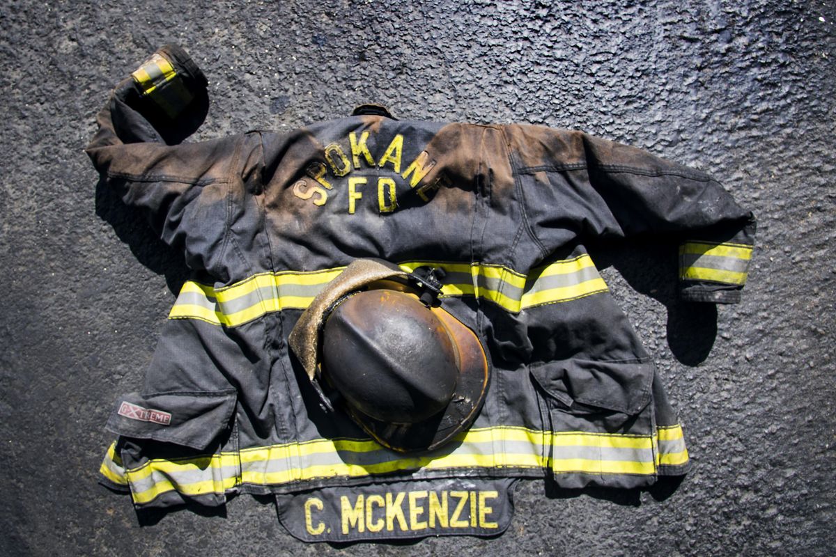 Spokane Fire Department firefigher Charles McKenzies charred turnout coat and helmut. (Colin Mulvany / The Spokesman-Review)