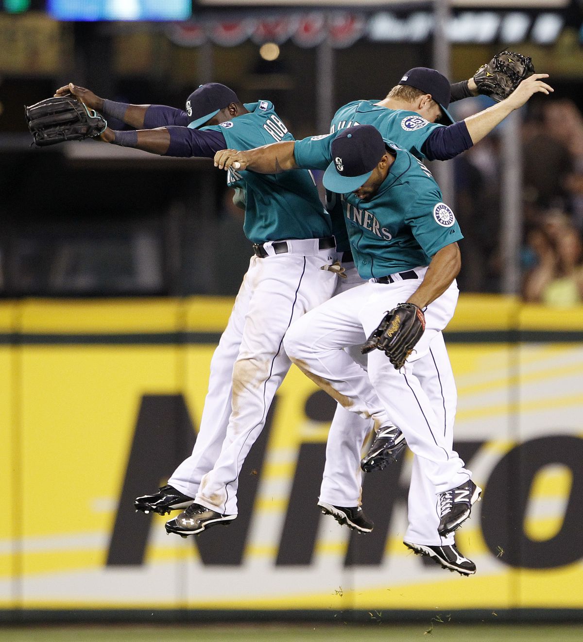 Trayvon Robinson, left, Eric Thames, front, and Michael Saunders celebrate victory. (Associated Press)