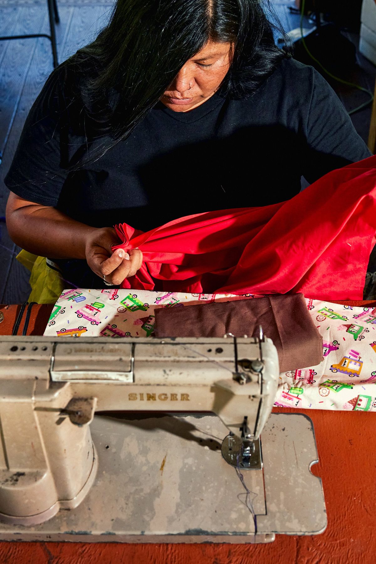 A woman sews clothes at the Miccosukee Indian Village, a tribal-run cultural center on the Miccosukee Indian Reservation, Fla., July 5, 2024. Islands deep in the Everglades protected the Miccosukee and other Native Americans from U.S. troops during the Seminole Wars of the 1800s – today, visitors can take Native-led tours of the islands.  (New York Times)