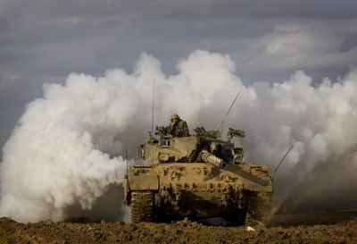 An Israeli tank advances along the Israel-Gaza border Thursday.  More than 750 Palestinians have been reported killed in Gaza since an Israeli offensive began on Dec. 27. At least 11 Israelis have been killed.  (Associated Press / The Spokesman-Review)