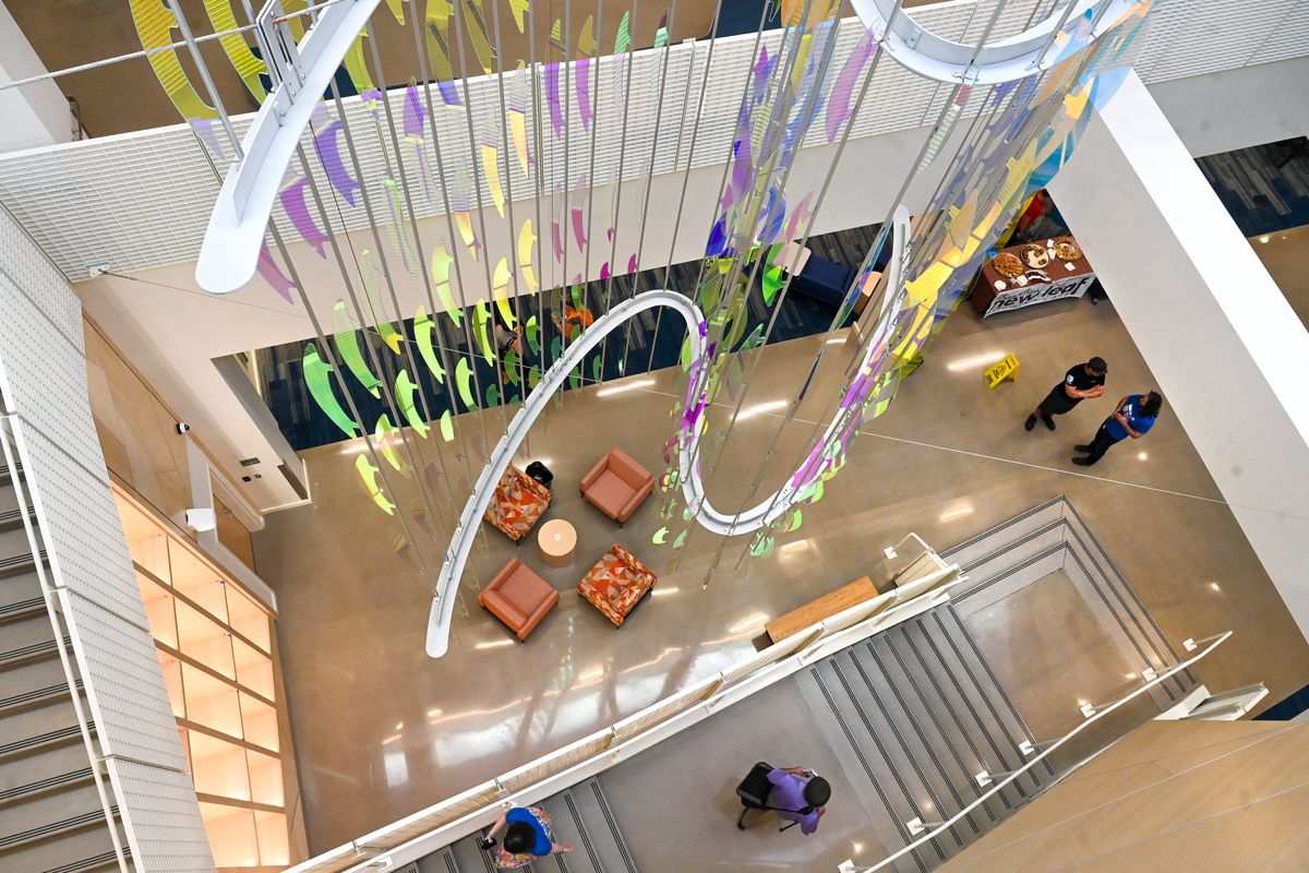 Central Library visitors tour the remolded building after opening ceremonies July 11 in downtown Spokane. Here they walk past the multifloor dichroic glass and aluminum artwork created by John Rogers.  (Dan Pelle/The Spokesman-Review)