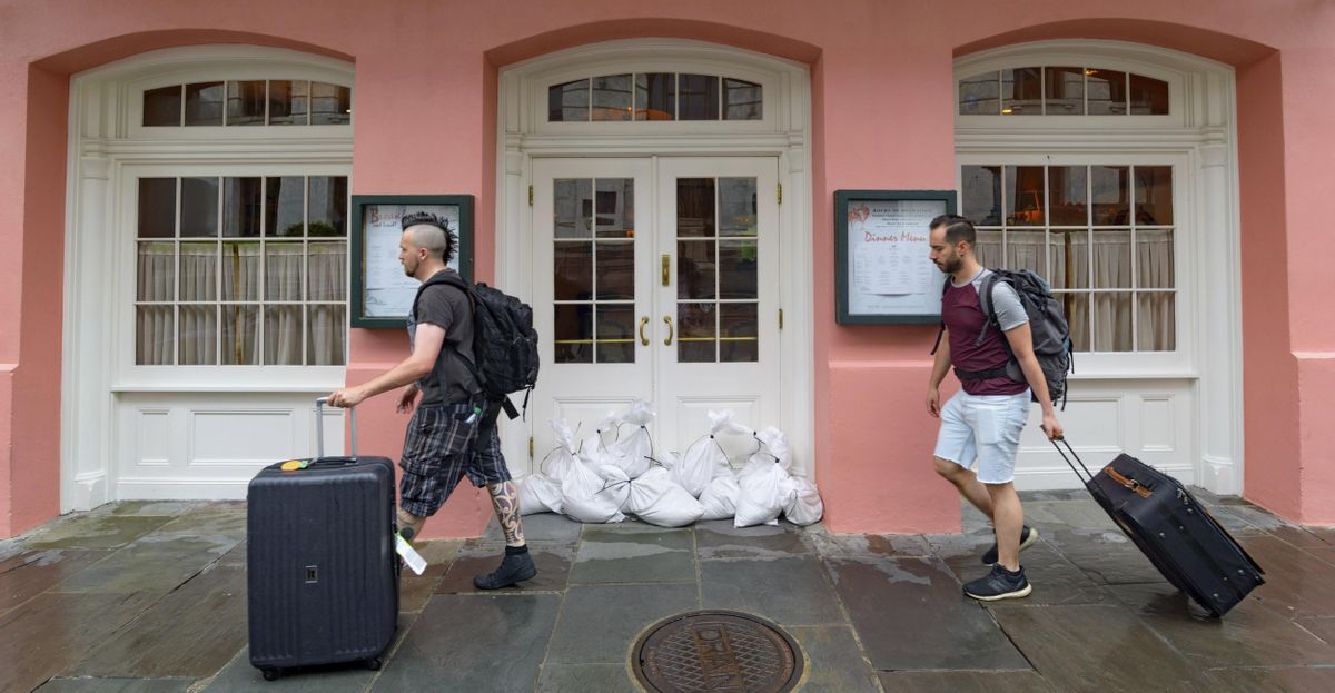 People walk past Brennan’s restaurant in the French Quarter with sandbags on the front door as bands of rain from Tropical Storm Barry from the Gulf of Mexico move into New Orleans, La., Friday, July 12, 2019. (Matthew Hinton / Associated Press)