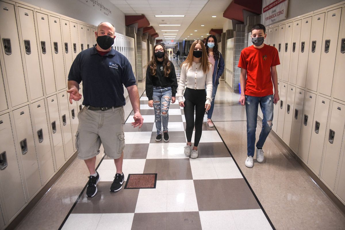 University High School biomed teacher Joe McCollum, left, leads his freshman students out of his classroom and down the school halls for a tour on the first day of in-person learning, Feb. 1 in Spokane Valley.  (DAN PELLE/THE SPOKESMAN-REVIEW)