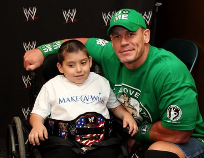 Jonny Littman, poses with WWE superstar John Cena in Uniondale, N.Y. (Associated Press)