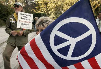 Protesters hold a flag with a peace symbol during a demonstration against the war in Iraqi in Sacramento, Calif. Associated Press
(Associated Press / The Spokesman-Review)