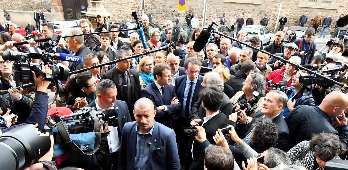 French centrsit presidential election candidate Emmanuel Macron, center, is surrounded by reporters as he visits at the Compagnons du Devoir house in Rodez, southern France, Friday, May 5, 2017. On the last day of France