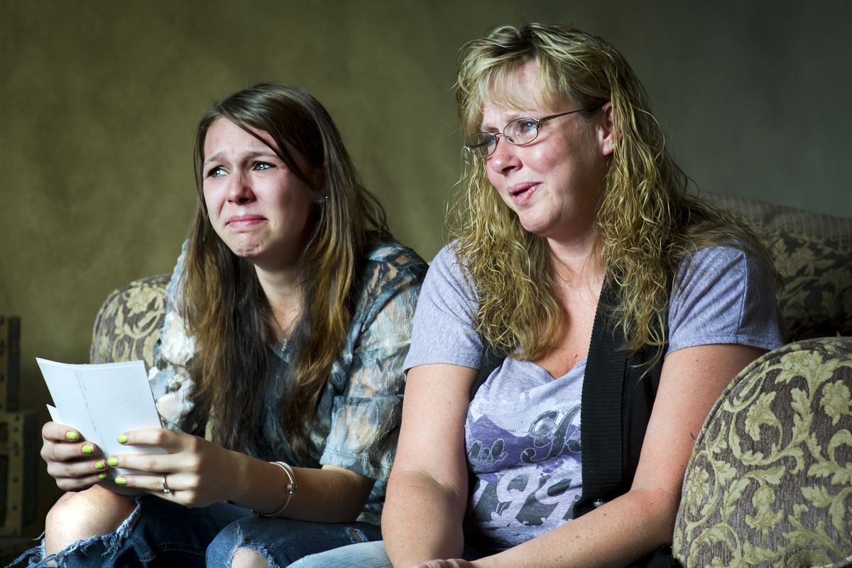 Stefanie Van Vlaenderen, left, and Angela Crigger, the niece and sister of James Edward Rogers, look at family photos Tuesday at Crigger’s house in Liberty Lake. Rogers was killed during a police standoff Monday night. (Colin Mulvany)