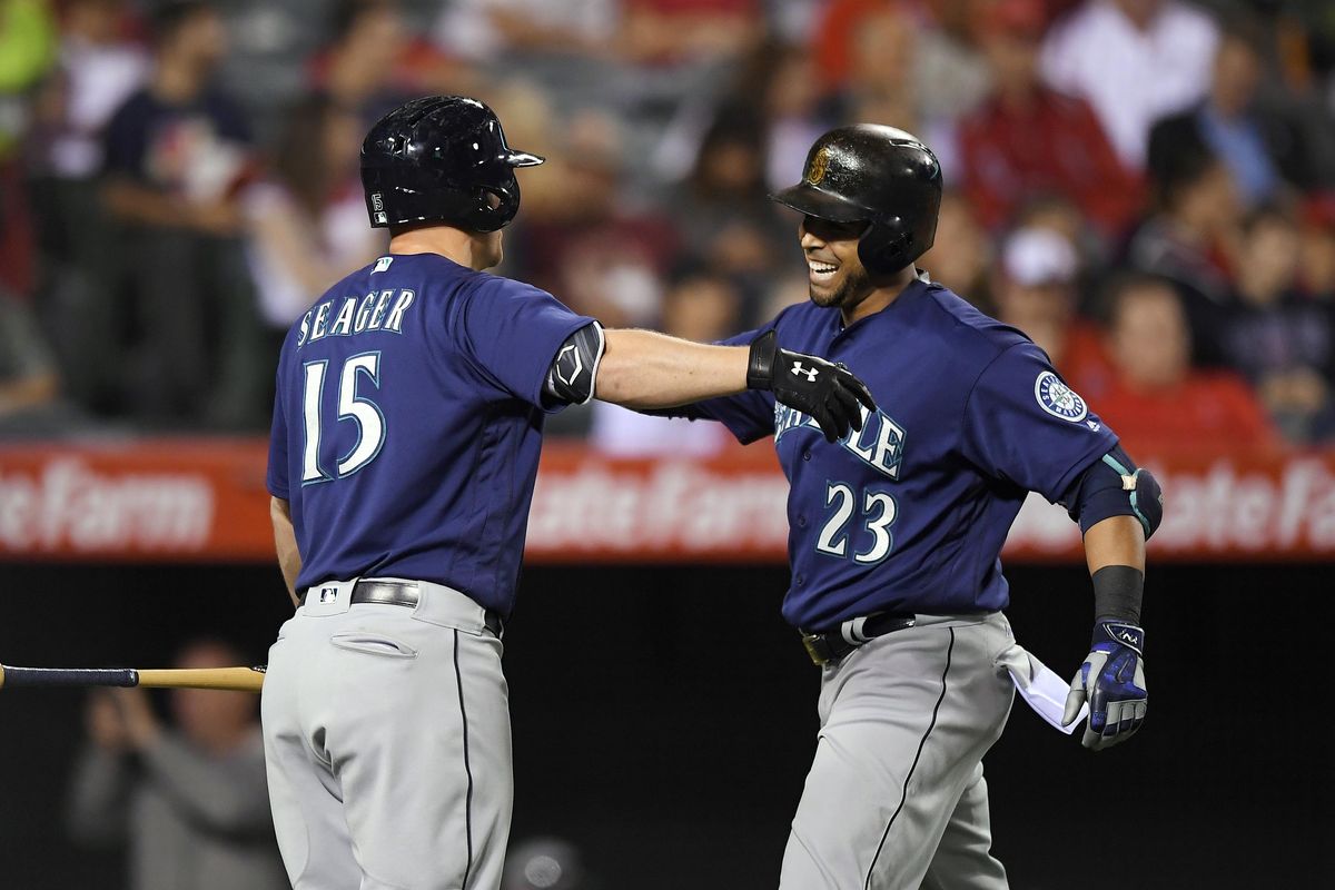 Nelson Cruz, right, is congratulated by Kyle Seager after hitting home run in the seventh inning for a 2-1 lead. Seager hit a homer in the fifth. (Mark J. Terrill / AP)