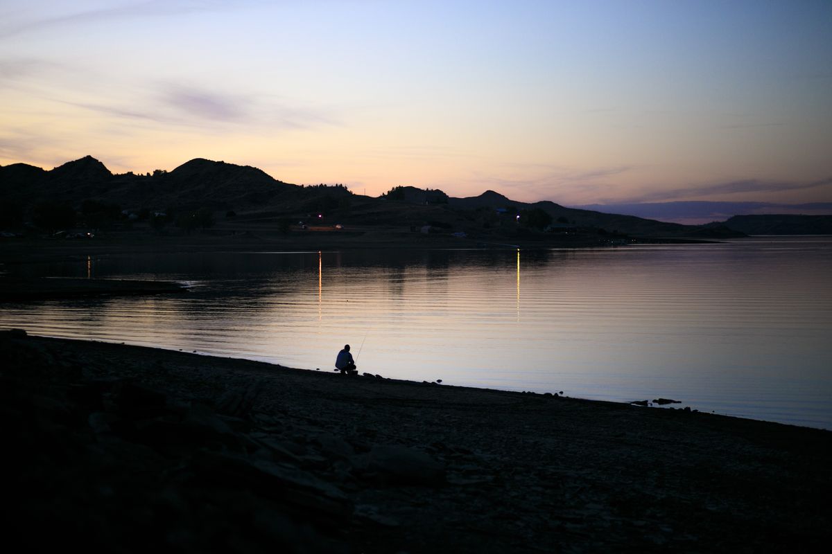 A man fishes by himself in the light of dusk Wednesday, June 2, 2021, at Hell Creek State Park in Garfield County, Mont.  (RYAN BERRY Billings Gazette)