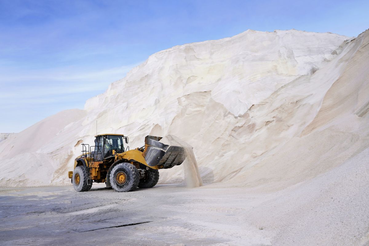 A front loader works at a large pile of road salt Wednesday in Chelsea, Mass., as preparation continues for a storm that is expected to dump a foot or more of snow. (Elise Amendola)
