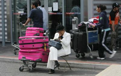 
A passenger waits outside Terminal 3 at London Heathrow Airport on Tuesday. Travelers in Britain continue to face problems, with confusion over shifting rules governing hand luggage. 
 (Associated Press / The Spokesman-Review)